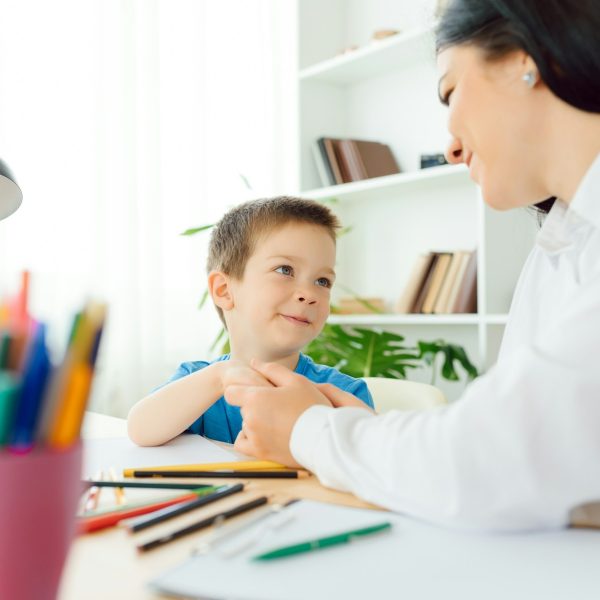 Child psychologist working with boy in office