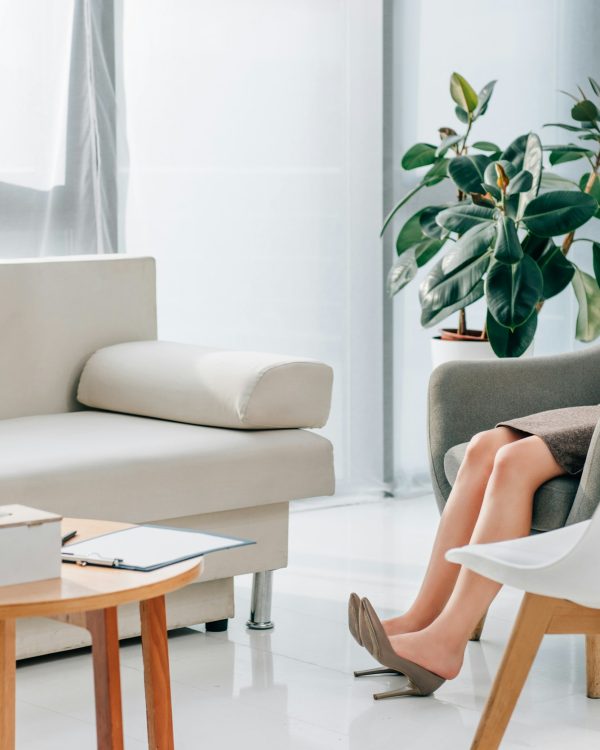 cropped view of tired psychologist in heels resting in office